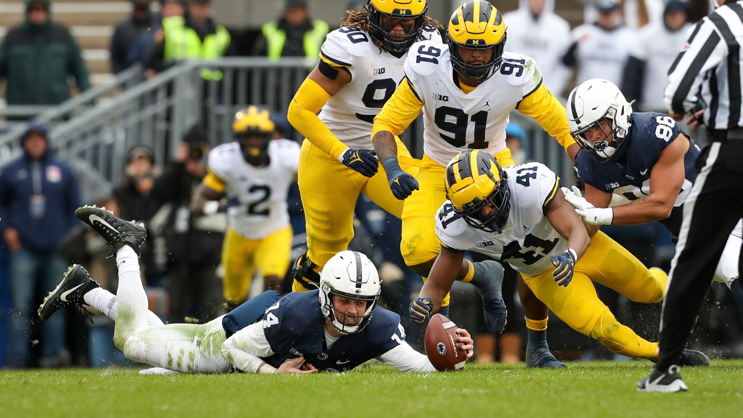 Michigan football looks to recover a Penn State fumble. James Franklin and Kalen King.