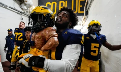 Josaiah Stewart carries the Paul Bunyan Trophy for Michigan Football