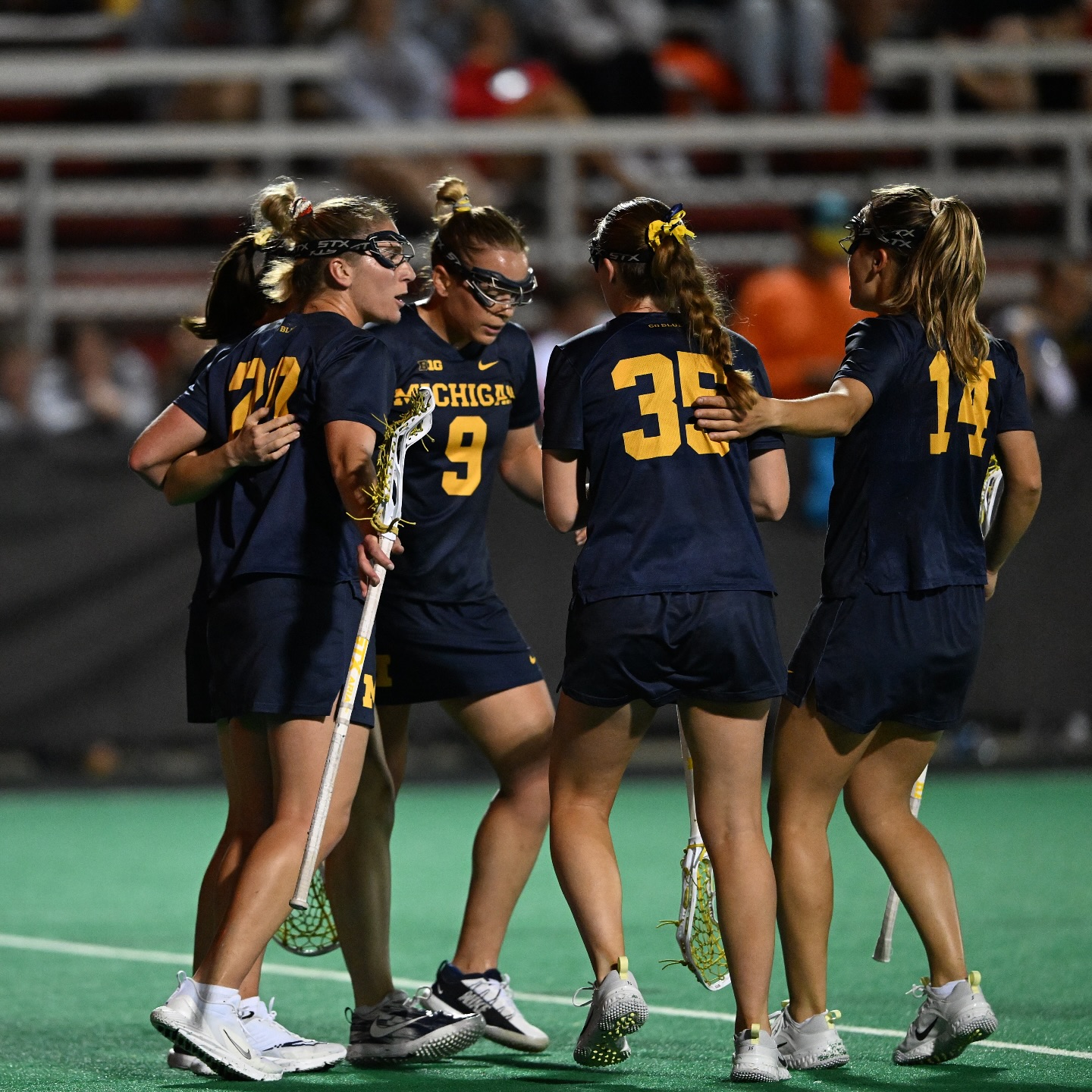 Michigan Women's Lacrosse squad huddled on the field